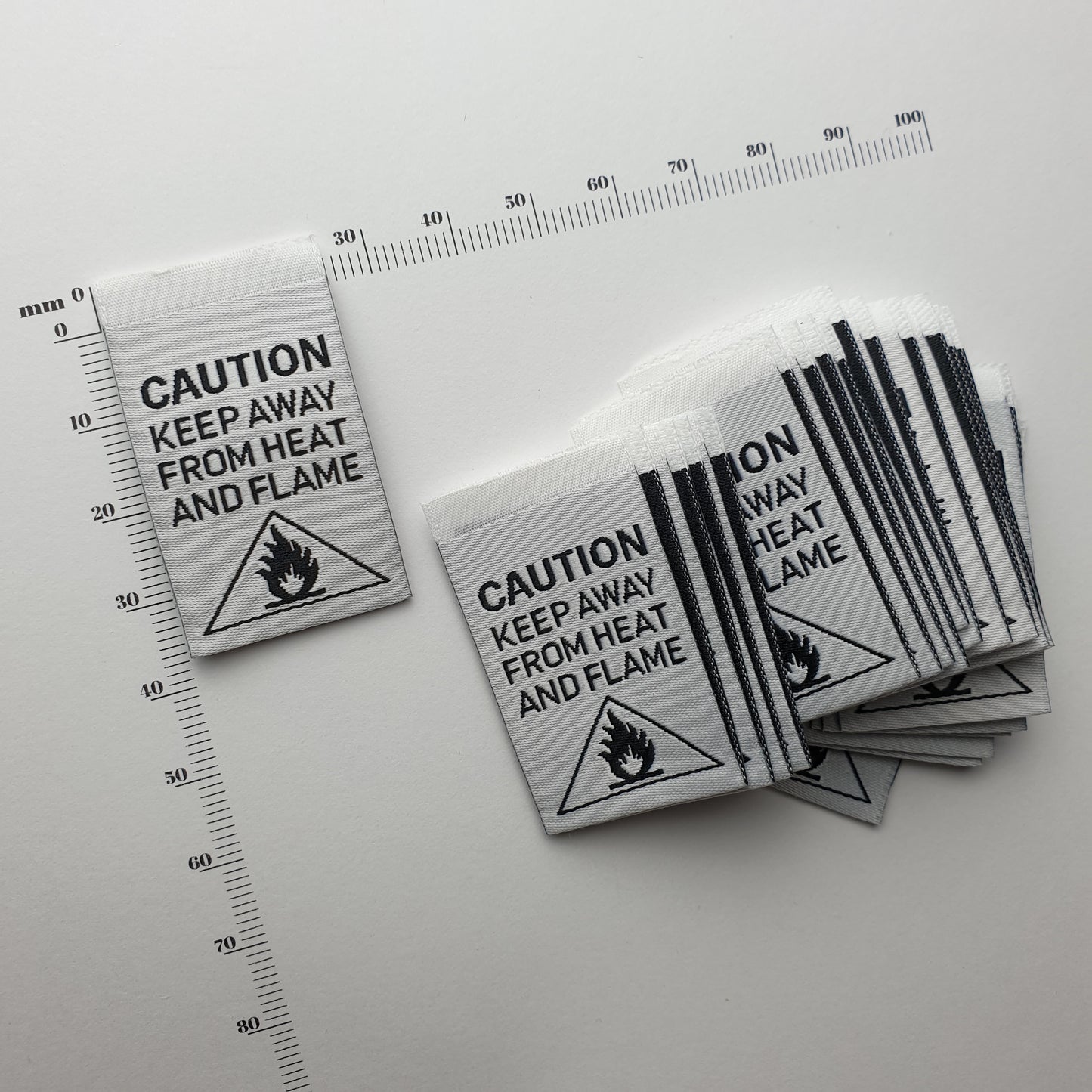 CAUTION - KEEP AWAY FROM HEAT AND FLAME - WOVEN LABELS